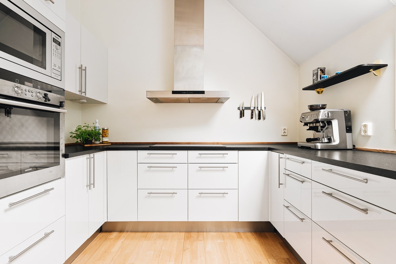 Kjøkkenet har godt med både skap- og benkeplass og inneholder innredning med slette fronter, laminat benkeplate, stål oppvaskkum og ventilator Galleribilde