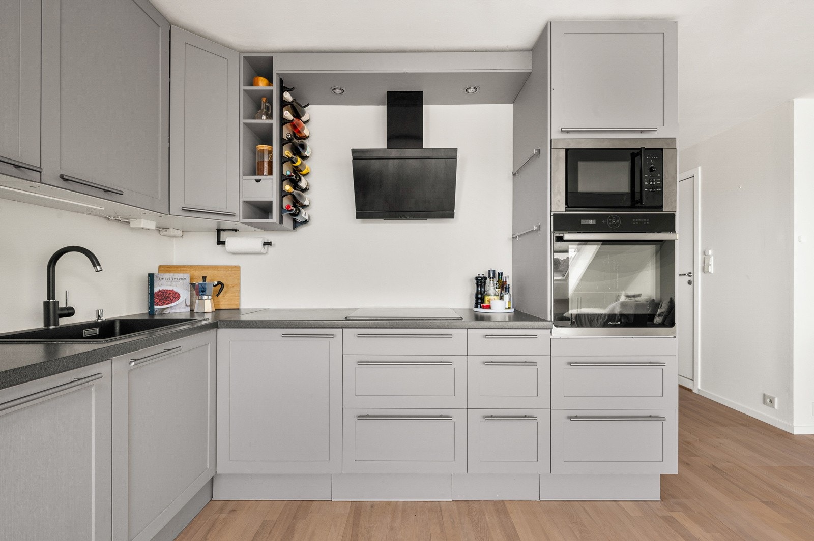 Kjøkken i moderne farge, med integrerte hvitevarer som komfyr, mikroovn, kjøleskap med frysedel og oppvaskmaskin. Galleribilde