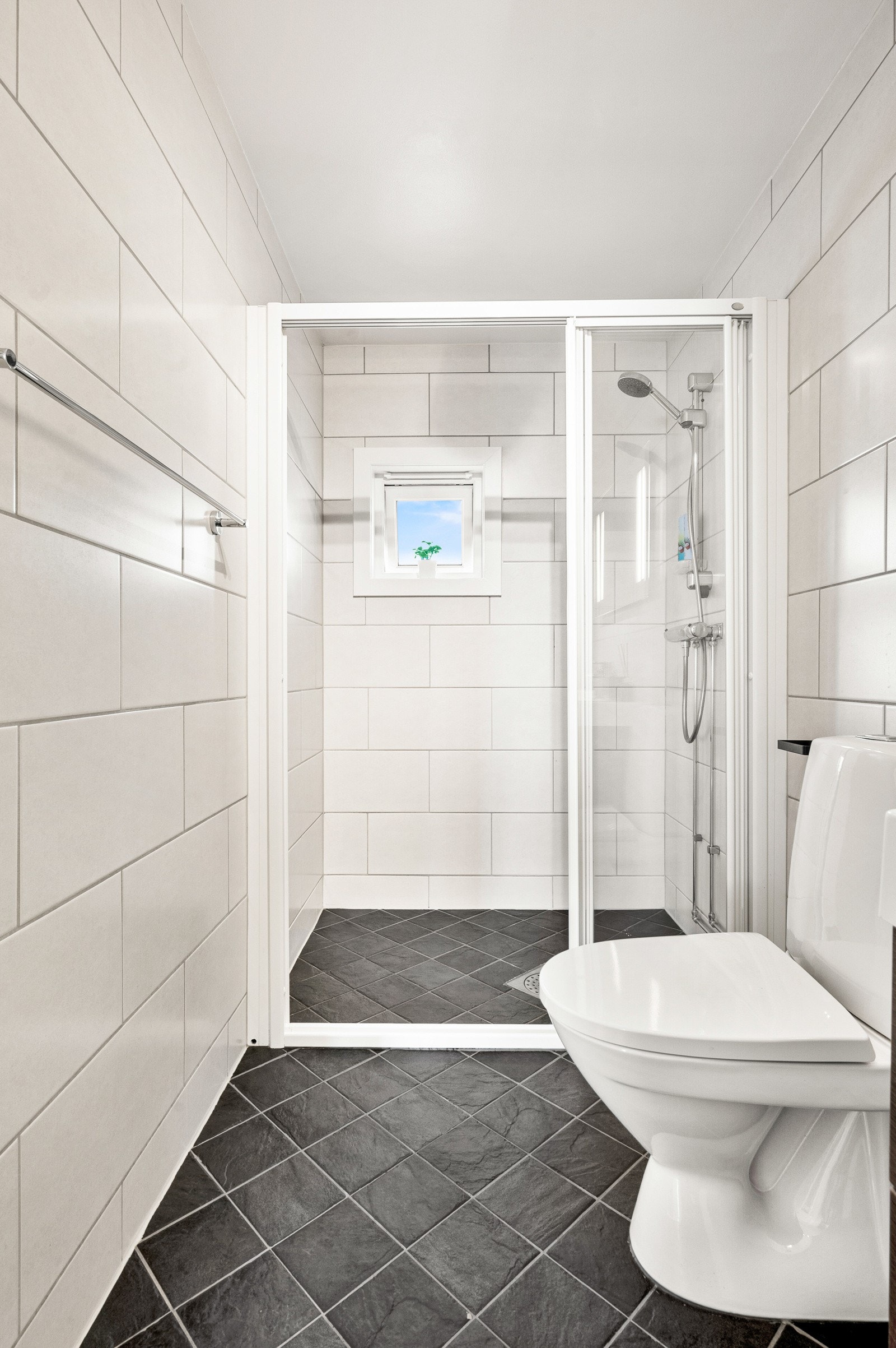 Badet har egen dusjsone, med praktiske skyvedører i glass. Galleribilde