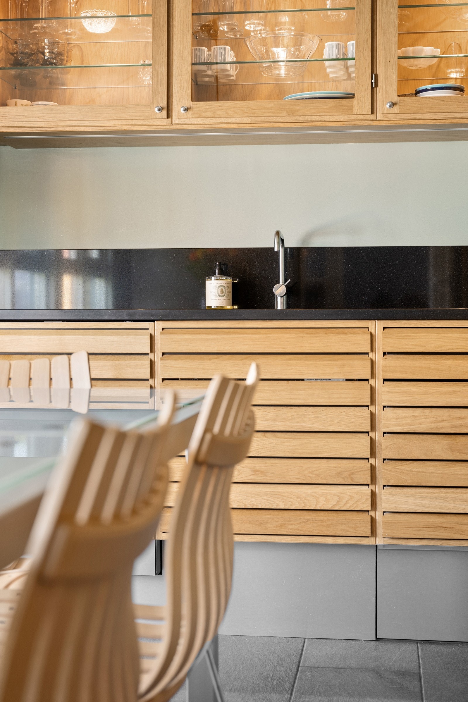 Kjøkkenet byr på integrerte hvitevarer som stekeovn og oppvaskmaskin fra Miele, samt induksjonstopp fra Witt (elegant all-black modell) og armatur fra Vola. Galleribilde