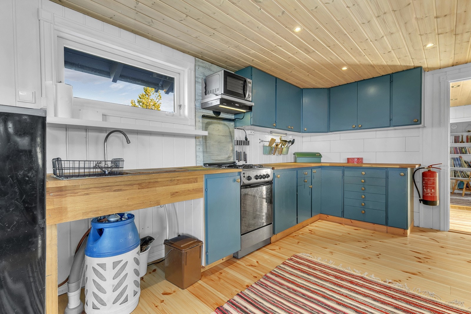 Kjøkkeninnredning med malte slette fronter og heltre benkeplate. Galleribilde