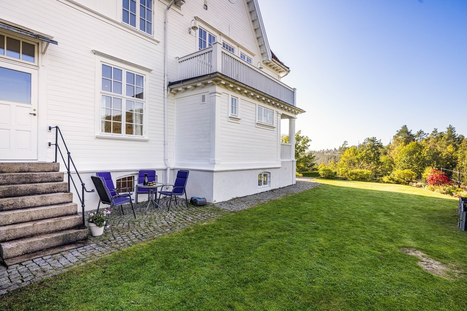 Meget pent opparbeidet hage med gressplener, terrasse, naturstein og smijernsrekkverk. Galleribilde