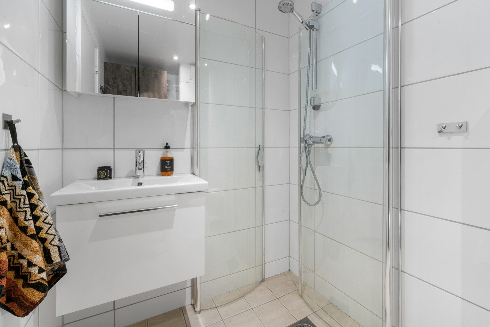 Innredning består av foldedører i dusj, veggtoalett og baderomsinnredning med heldekkende servant, samt belyst speil. Galleribilde