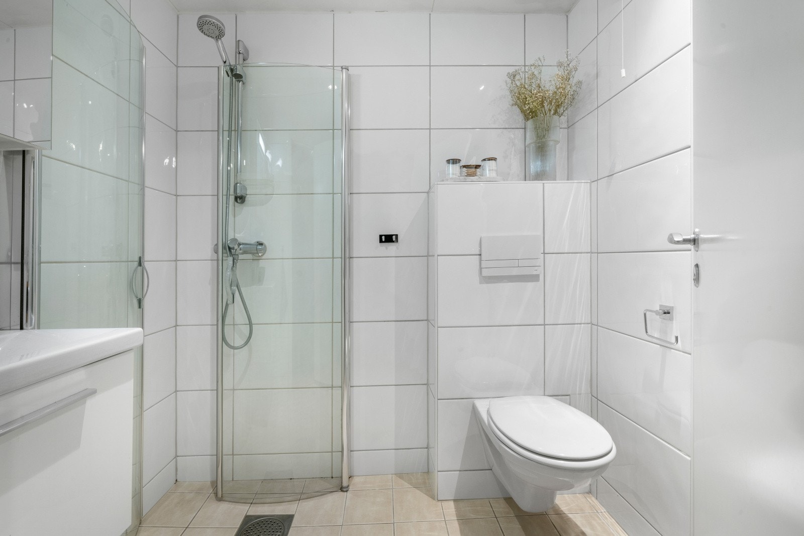 Leilighetens bad/vaskerom er helfliset i tidløs stil og fremstår moderne med downlights i himling. Galleribilde