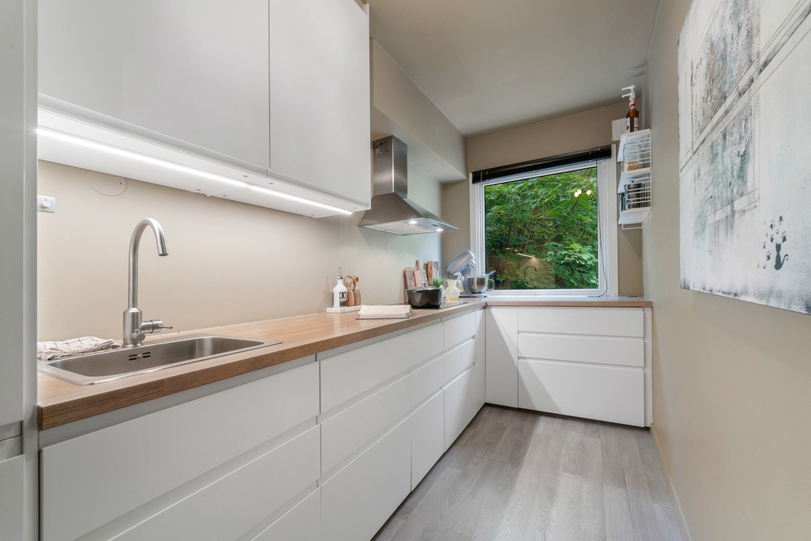 Her har vi innredning fra Ikea med hvite glatte fronter og laminert benkeplate med kjøkkenvask. Galleribilde