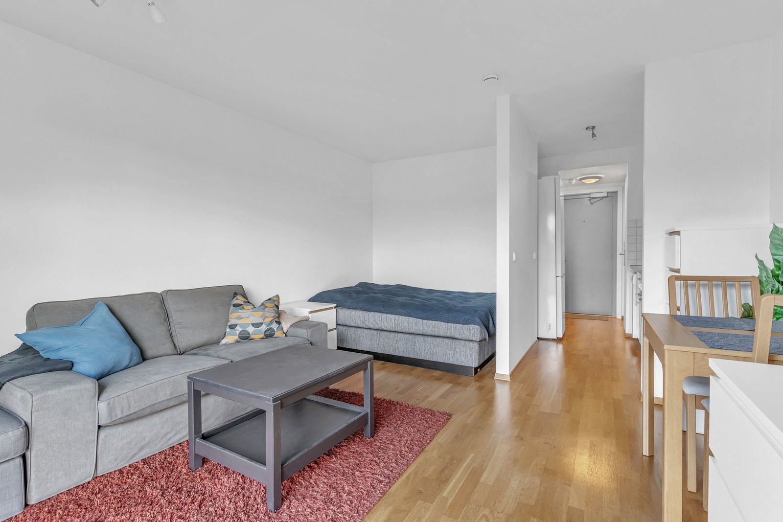 Leiligheten har en delvis åpen stue- og kjøkkenløsning som gjør rommet til et sosialt oppholdsrom. Galleribilde