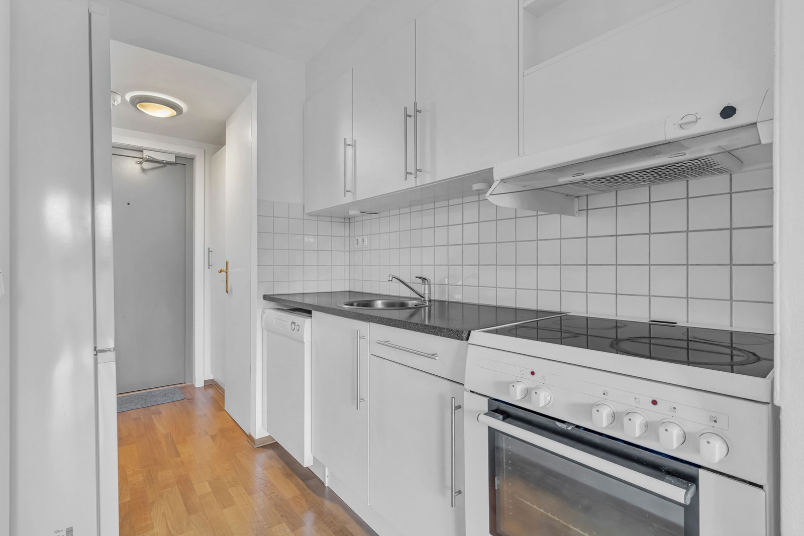 Kjøkkenet har lys innredning fra 2004 med slette fronter i matt utførelse. Her er det benkeplate i laminnert utførelse med nedsenket oppvaskkum i rustfritt stål med ett-greps armatur. Galleribilde