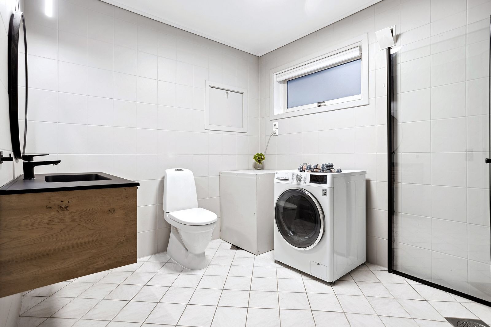 Badet inneholder toalett, servant, dusj og vaskemaskin. Galleribilde