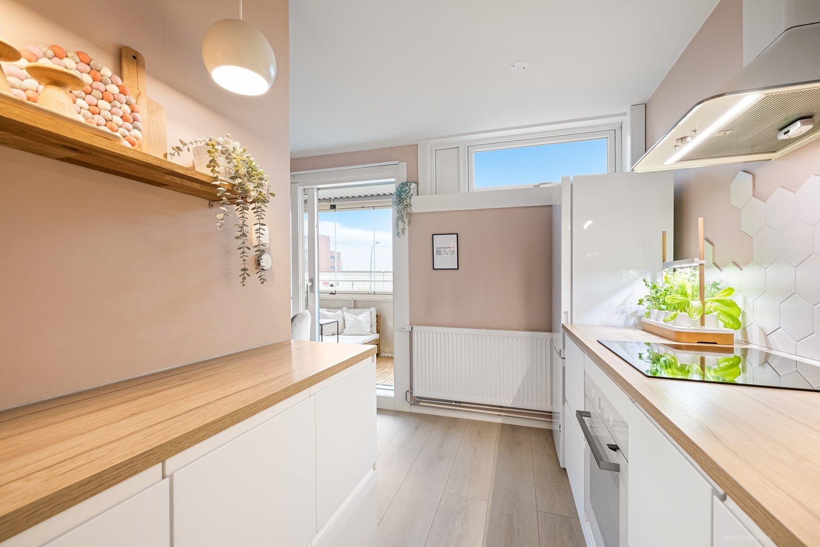 Lys og moderne kjøkkenløsning med god benkeplass og utgang mot balkong. Galleribilde