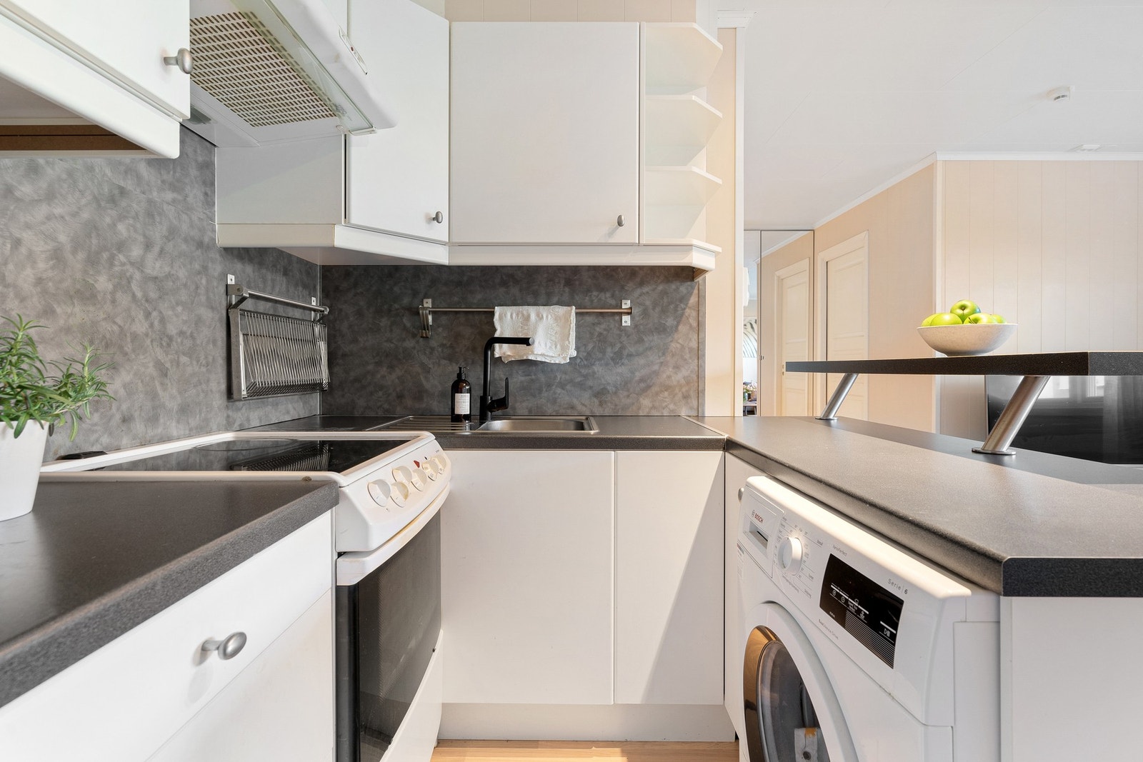 Stilrent kjøkken med plane fronter og laminerte
benkeplater. Galleribilde