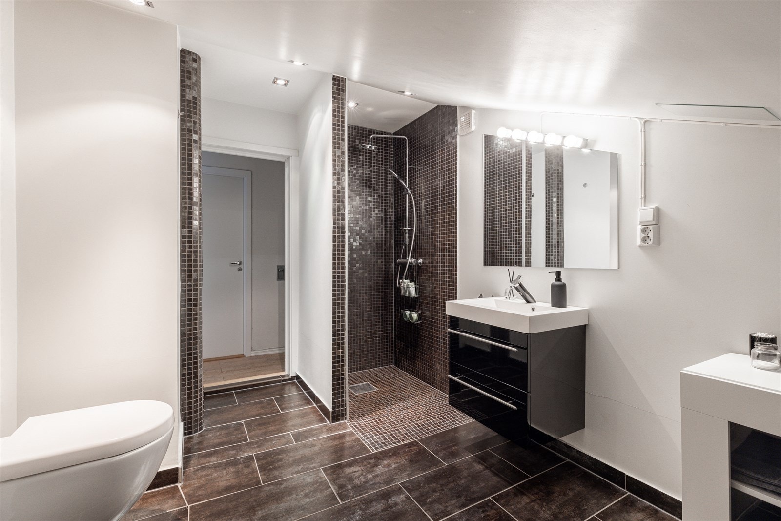 Badet er romslig, med dusjnisje, varmekabel og opplegg for vaskemaskin samt tørketrommel. Galleribilde