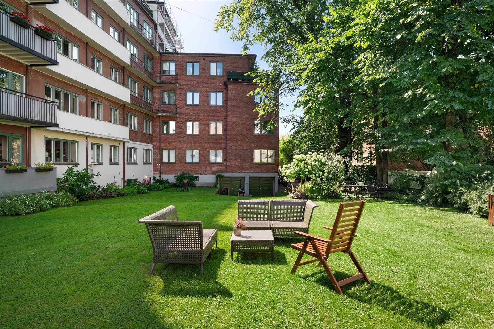 Sameiet har en stor bakgård med gressplen og felles utemøbler til beboerne Galleribilde