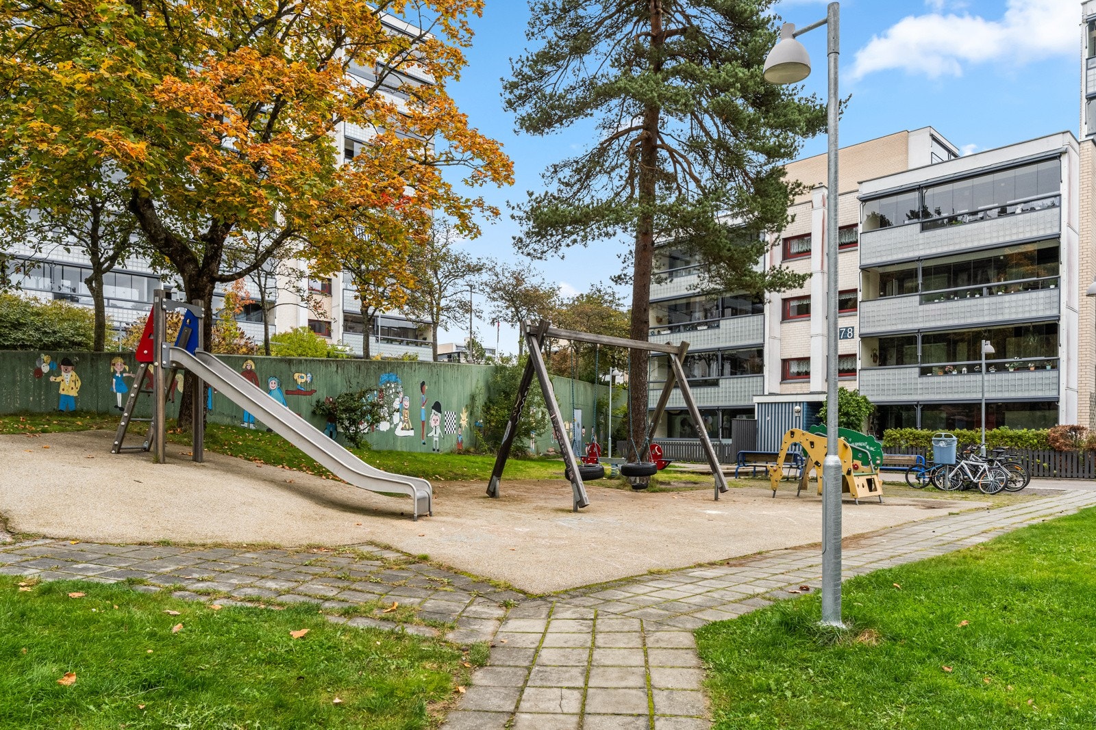 Rett utenfordørs finner barna en lekeplass som de kan få glede av. Galleribilde