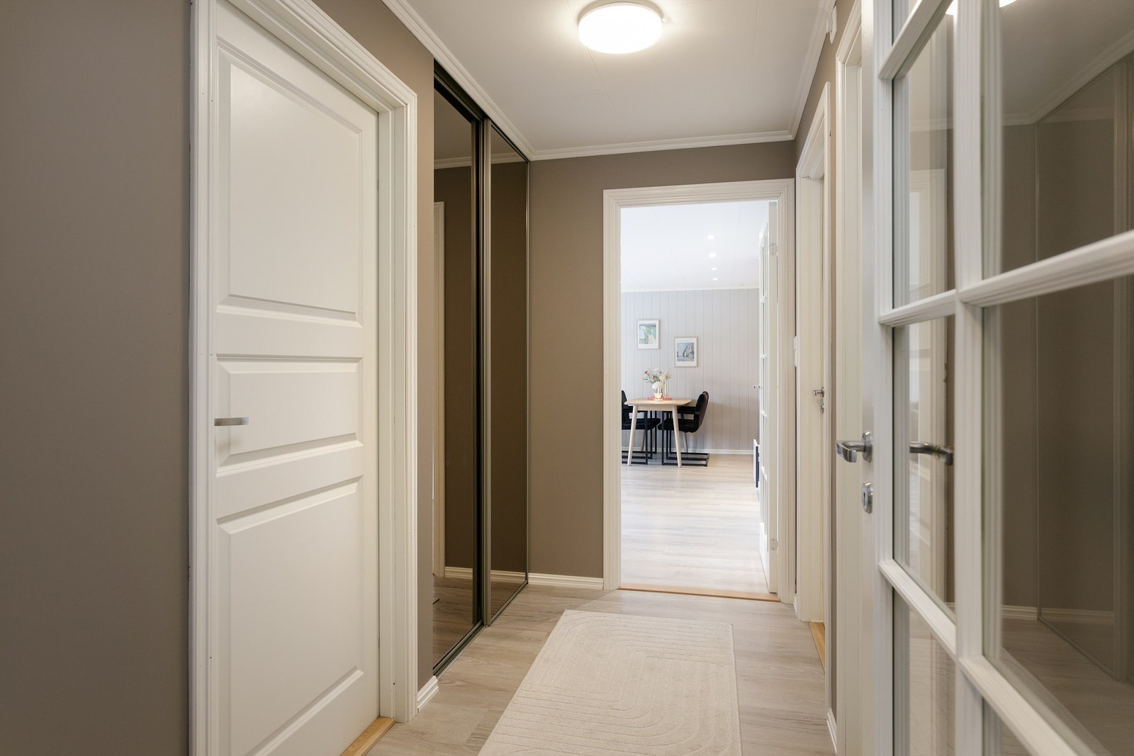 Vindfanget er separert fra gangen med innerdør med glassfelter. Legg og merke til skyvedørsgarderoben Galleribilde