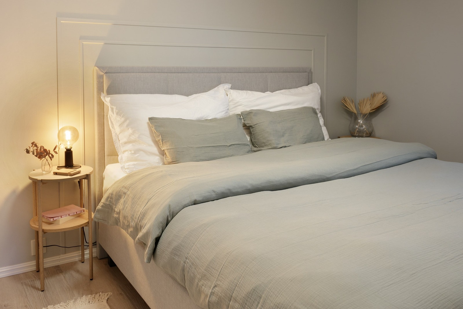 Fin omramming til den naturlige plasseringen av seng med dekorlister. Veggflatene er malt i en sval og behagelig gråtone Galleribilde