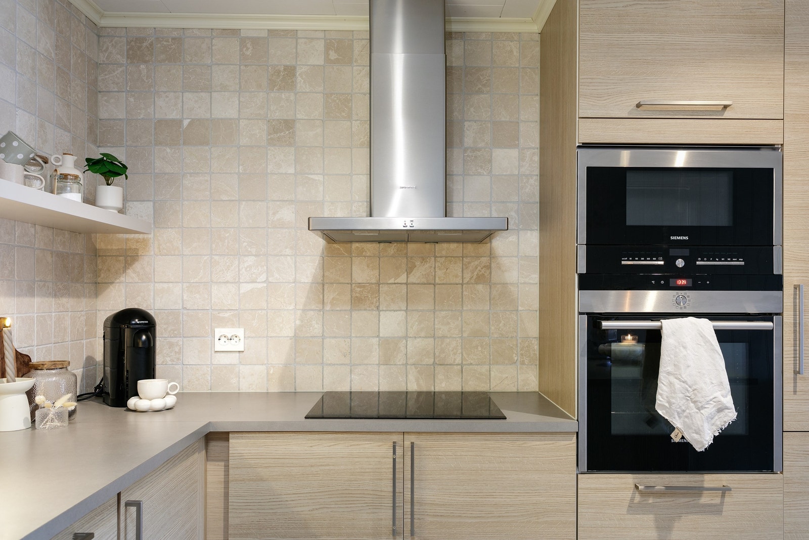 Stekeovn og mikrobølgeovn er plassert i behagelig høyde og de flislagte veggene gjør det lettvint å holde flatene ren i både koke- og stekesonen Galleribilde