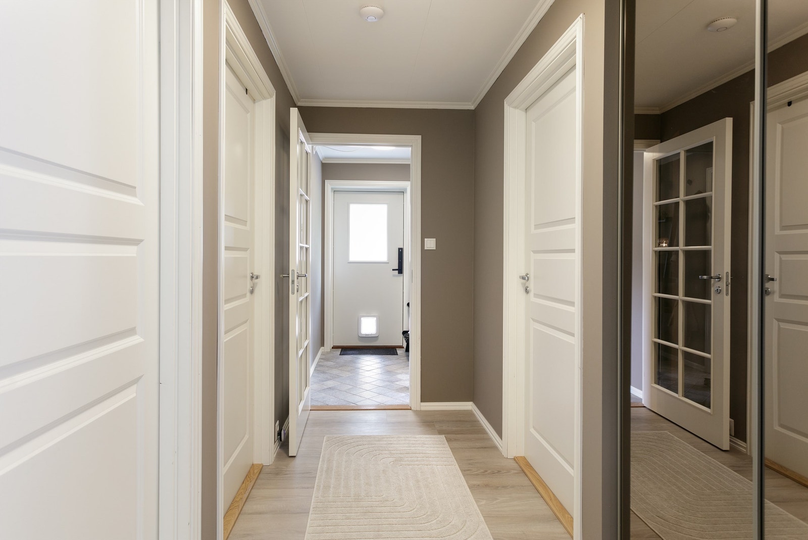 Velkommen inn! Gangen er malt med fargen muskat som er en varm beigtone og gir et godt førsteinntrykk av leiligheten Galleribilde