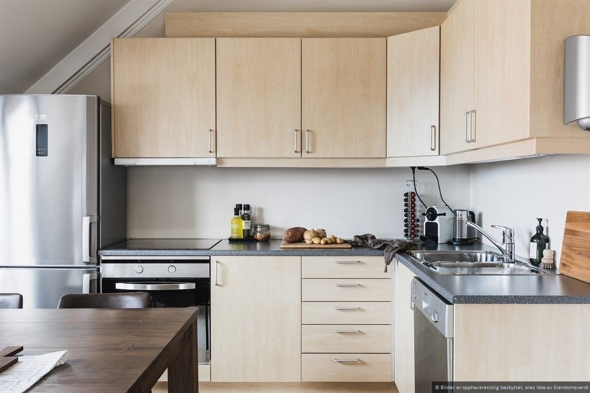 Kjøkken i åpen løsning mot stuen. Innredning fra IKEA med glatte overflater. Galleribilde