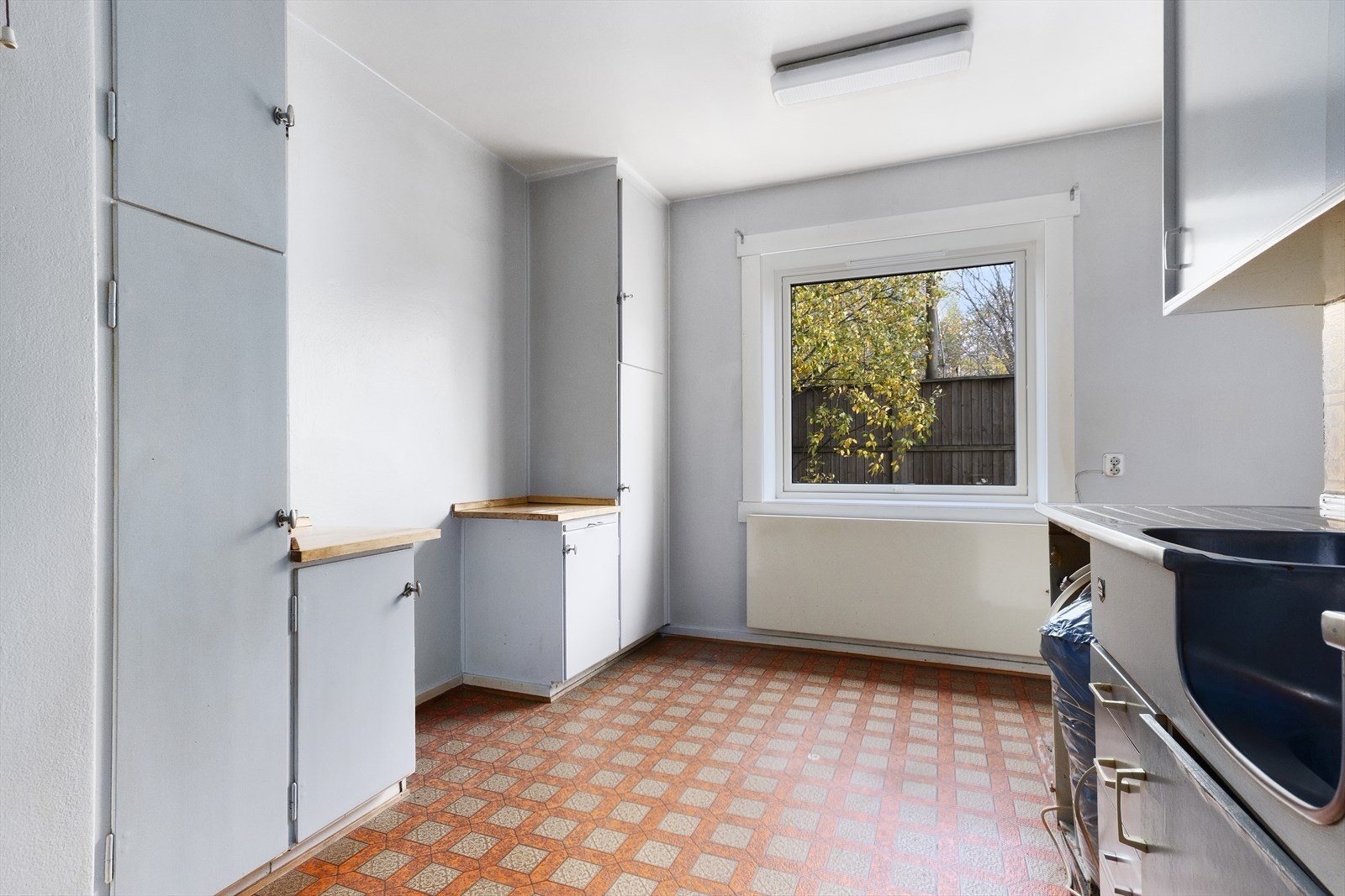 Stort kjøkken med spiseplass ved vindu. Alle flater i boligen trenger full oppussing/modernisering Galleribilde