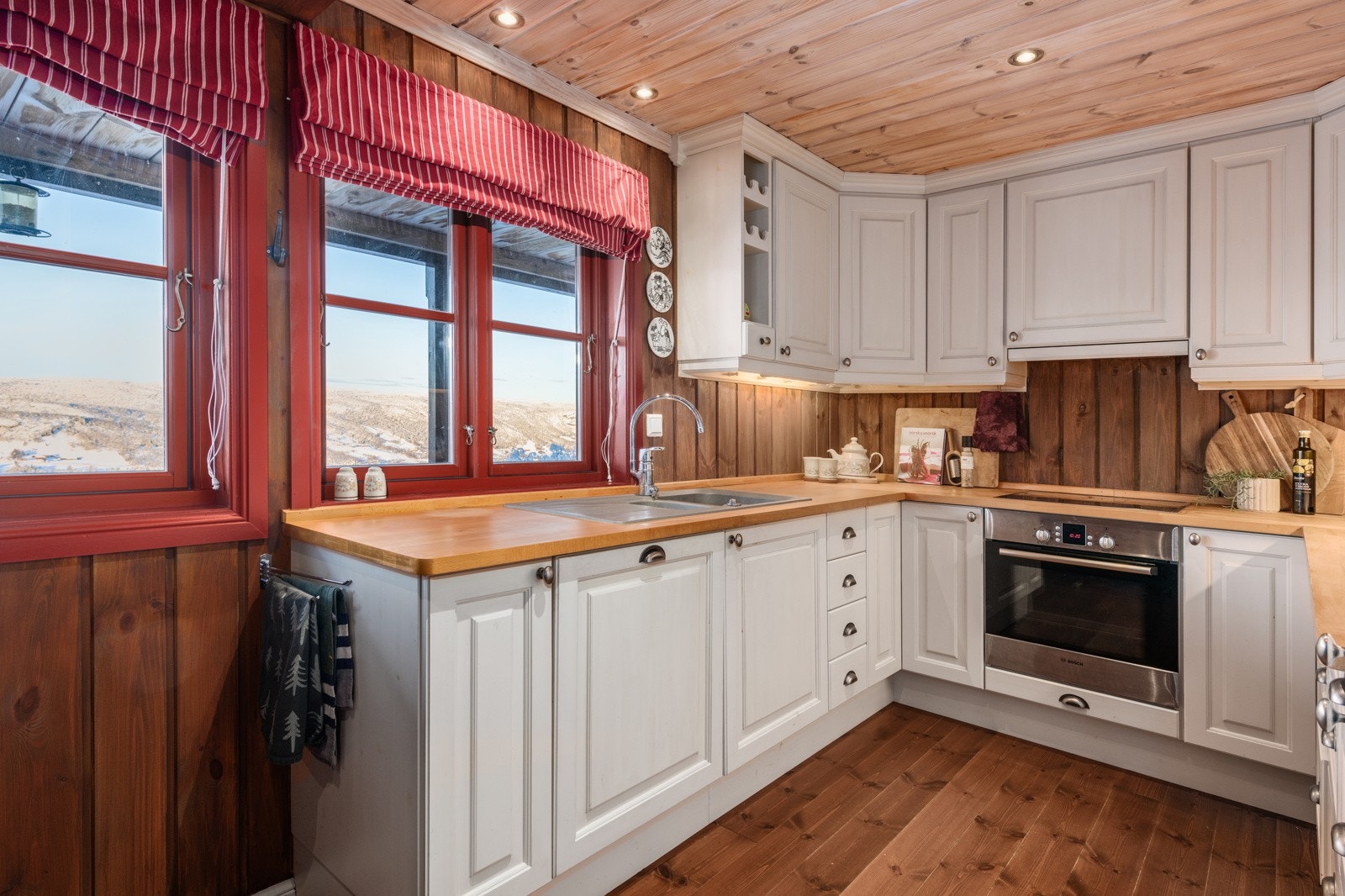 Det er en flott og stilren kjøkkeninnredning med masse skap og benkeplass. Galleribilde