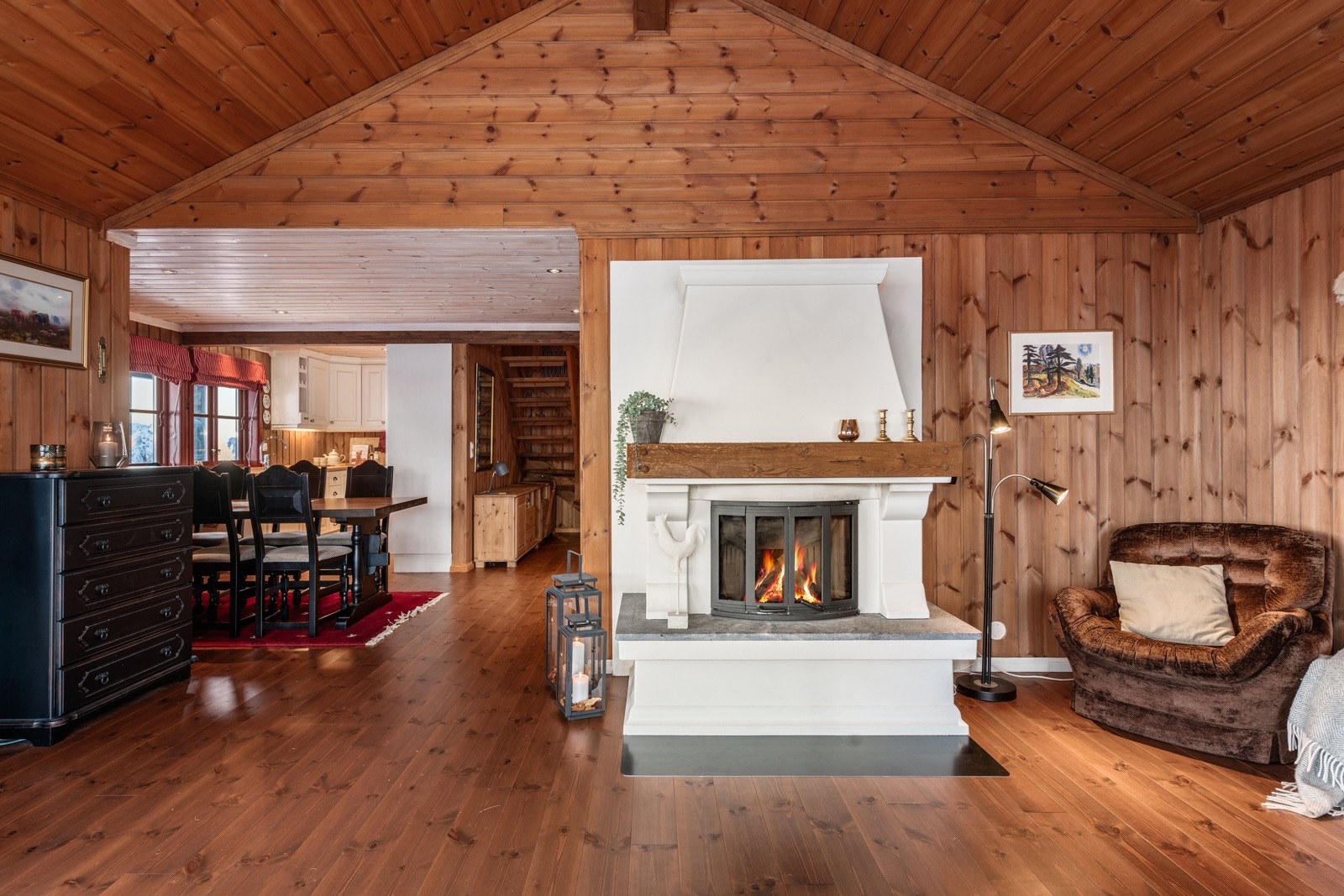 Stuen innehar også en stor murt peis med innsats med dører. Den er malt i hvit og står pent i stil til resten av hytten. Galleribilde
