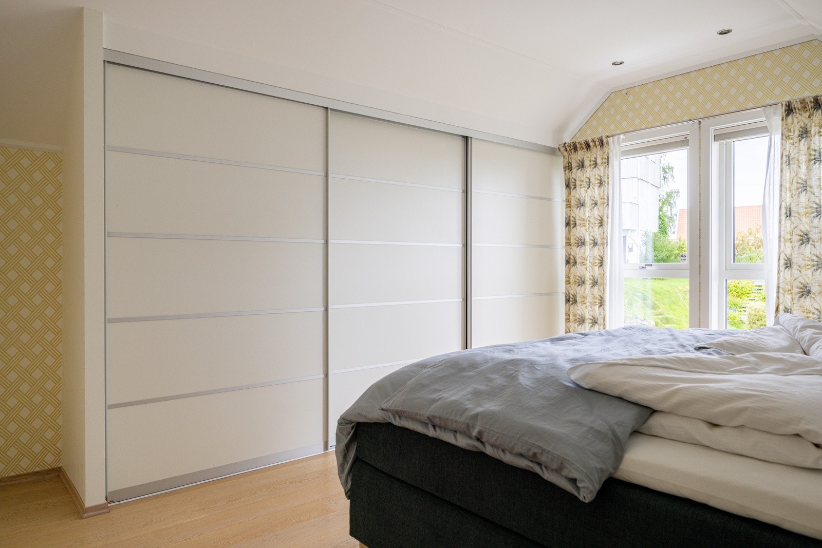 På soverommet har du god plass til stor dobbeltseng med tilhørende nattbord, samt rikelig med oppbevaringsplass i stor plassbygget skyvedørsgarderobe. Galleribilde