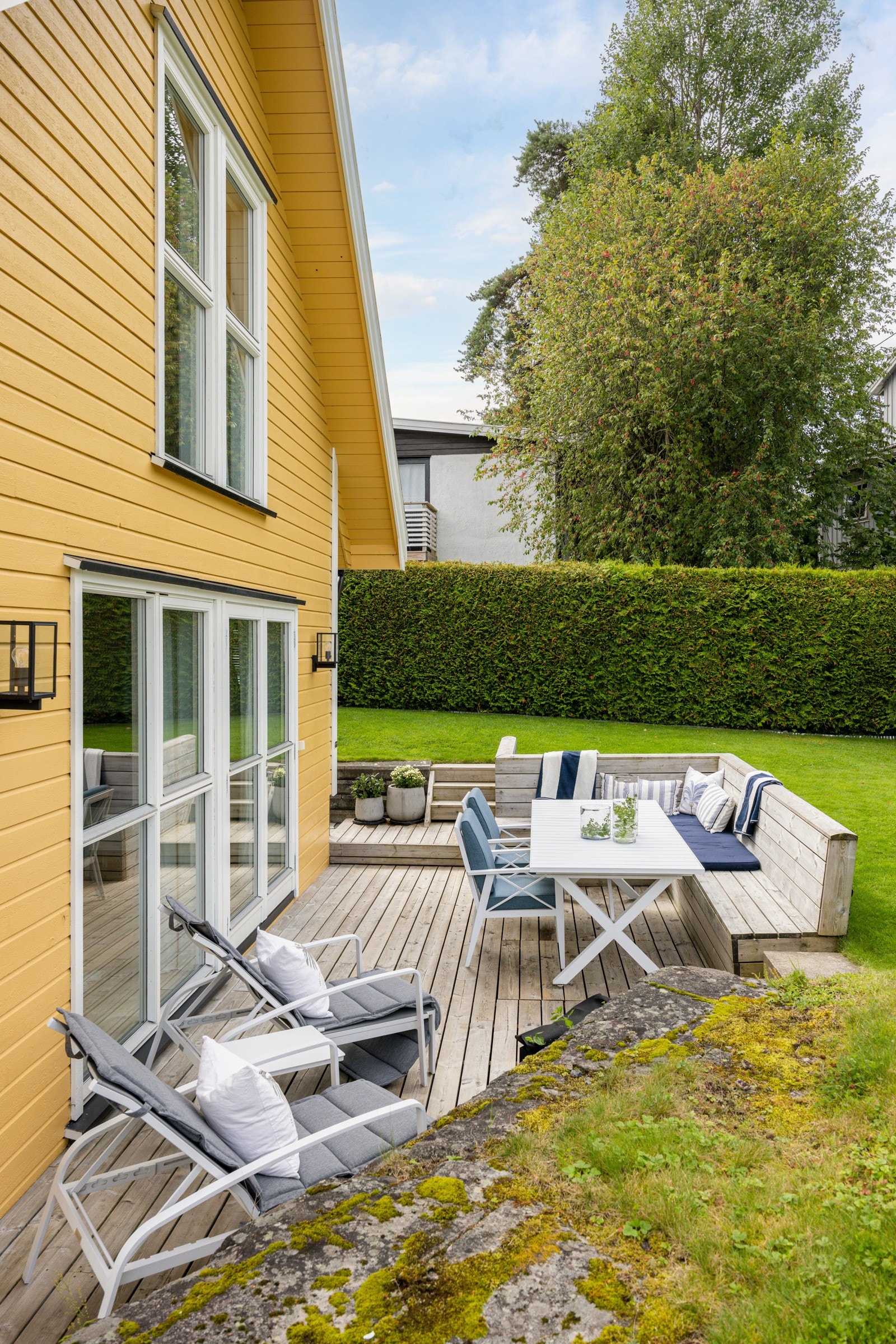 Tomten er opparbeidet med gruset innkjørsel og hageanlegg med gressplen, hekker, trær og diverse beplantning. Galleribilde