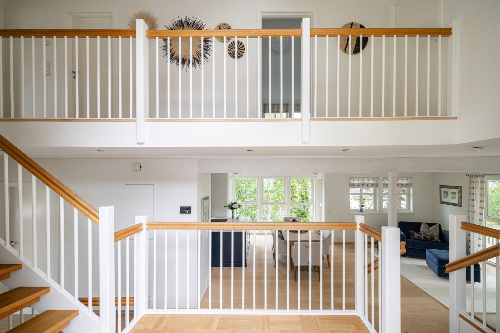 Entréen har nydelig parkett på gulv og store vindusflater rundt døren som slipper inn rikelig med naturlig lys. Den åpne løsningen til begge etasjene gir en åpen og luftig romfølelse. Galleribilde