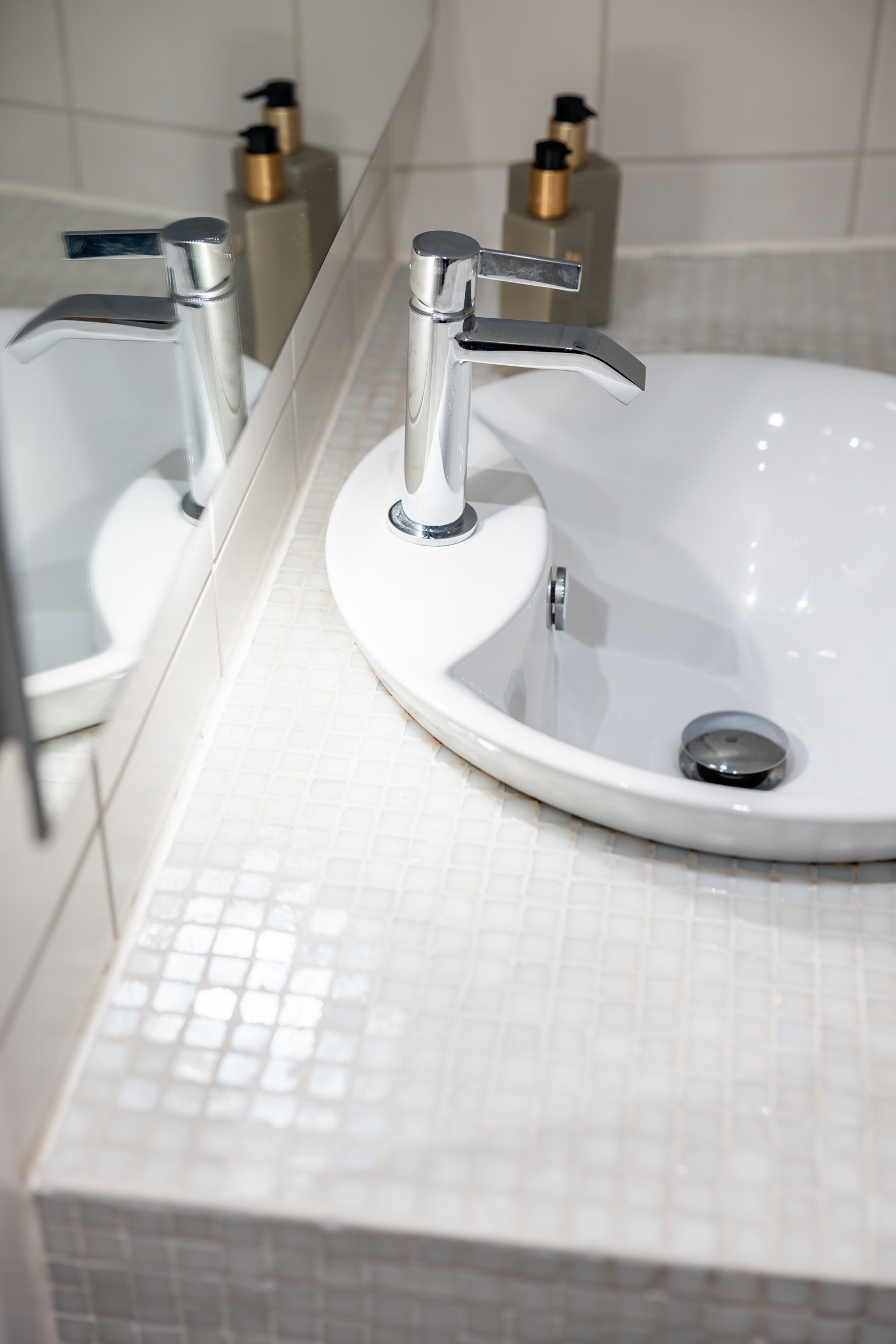 Flott flislagt innredning med nedfelt servant, stort speil med belysning over. Galleribilde