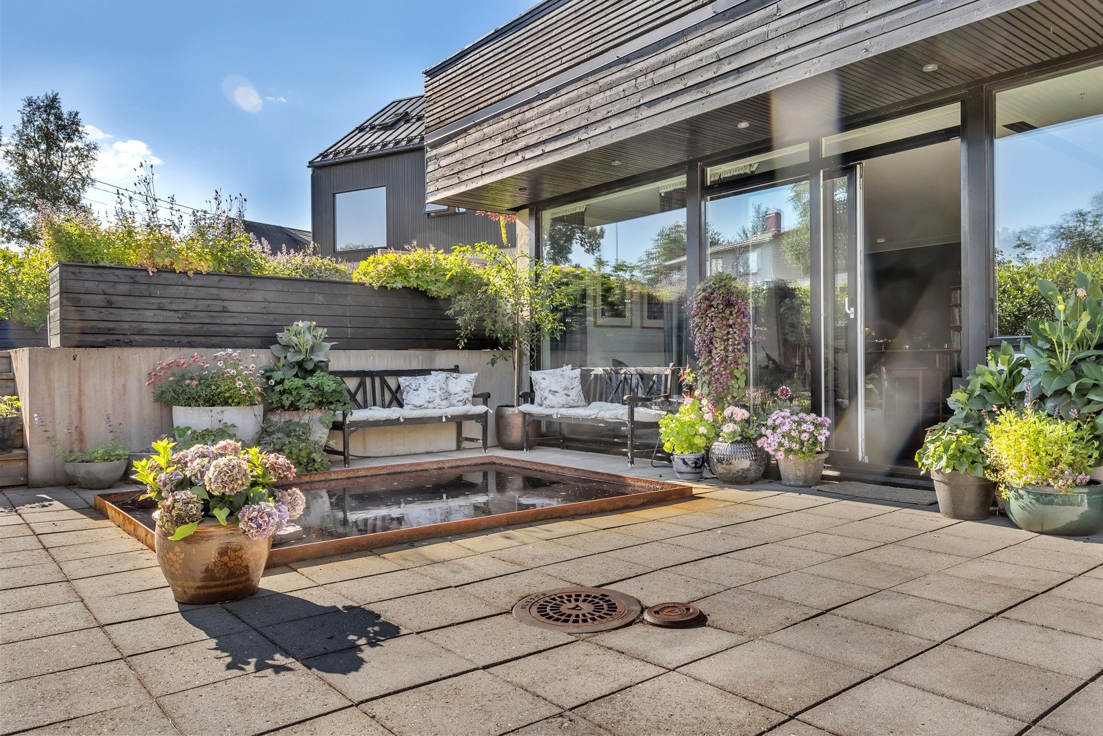 Patioen, eller bakhagen, er sjeldent flott! Her er det nydelig arrondert med betongheller, vannbad, flott beplanting, plattinger m.m. Galleribilde