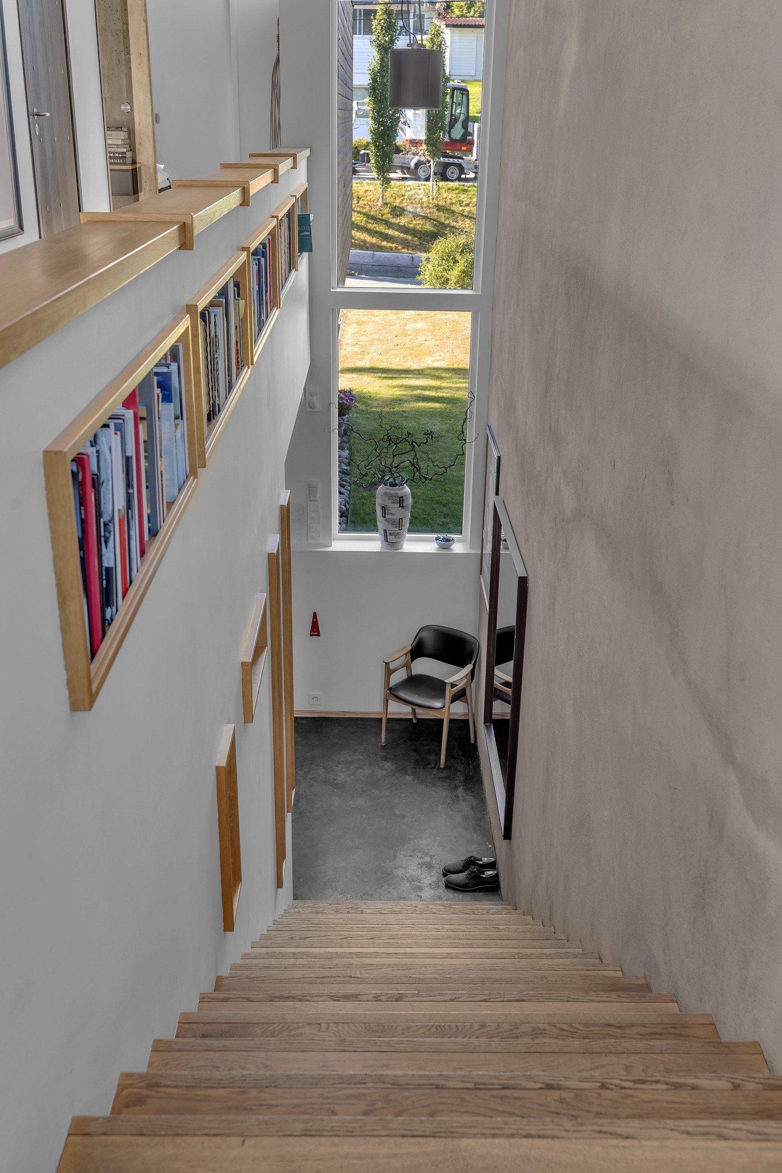 Åpen og fin trappegang opp til 2. etasje. Legg merke de flotte detaljene med eikehyller som er skjært inn i betongen Galleribilde