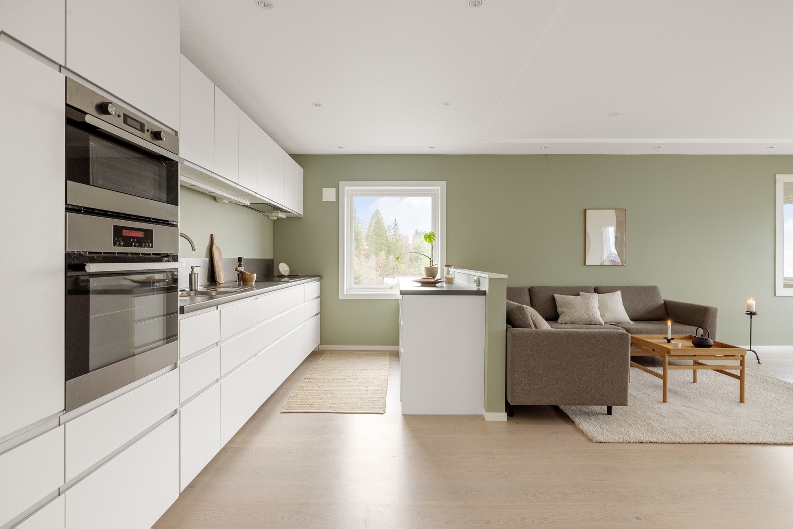 Det er åpen løsning mellom kjøkken og stue med en kjøkkenøy i mellom Galleribilde