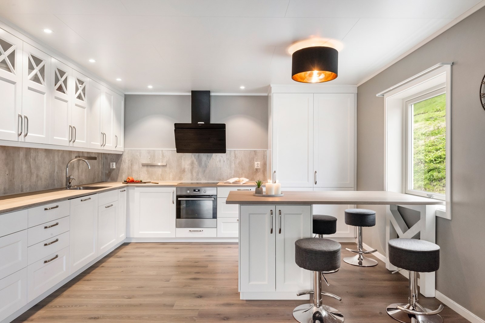 Kjøkkeninnredningen har profilerte malte fronter, laminat benkeplate, ventilator hette. Kitchenboard mellom benk og overskap. Galleribilde