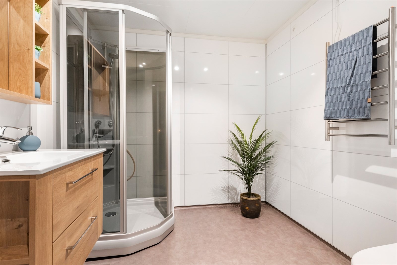 Badet i 1. etasje er utstyrt med dusjkabinett, heldekkende servant med skuffeseksjon, og speilskap. Frittstående toalett. Rommet er romslig og pent innredet. Galleribilde