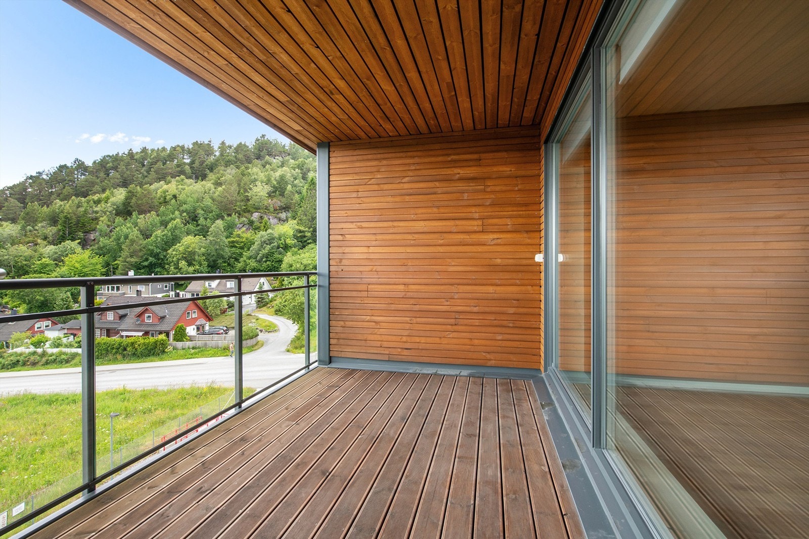 Vestvendt terrasse som er overbyd. Glassrekkverk mot vest Galleribilde