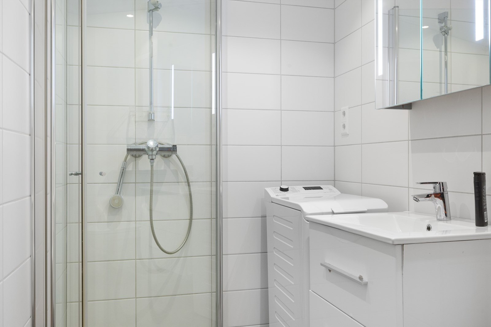 Dusjnisje med sammenleggbare glassdører og armatur på vegg Galleribilde