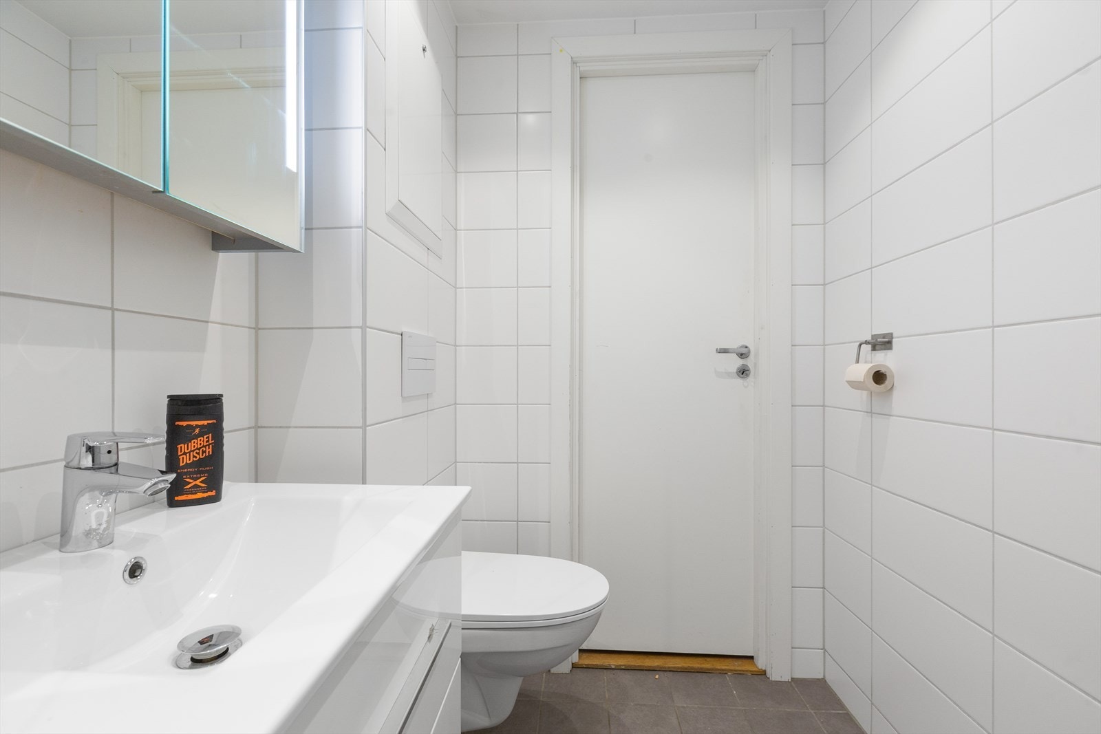 Slett baderomsinnredning med enkel servant, skuffer og speilskap med lys Galleribilde