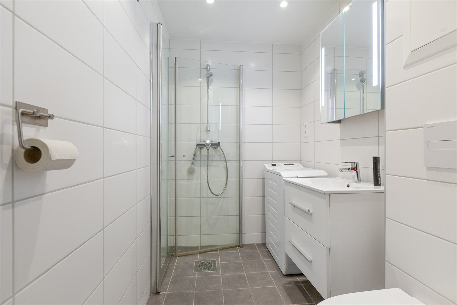 Helfliset baderom med underliggende varmekabler og opplegg for vaskemaskin Galleribilde