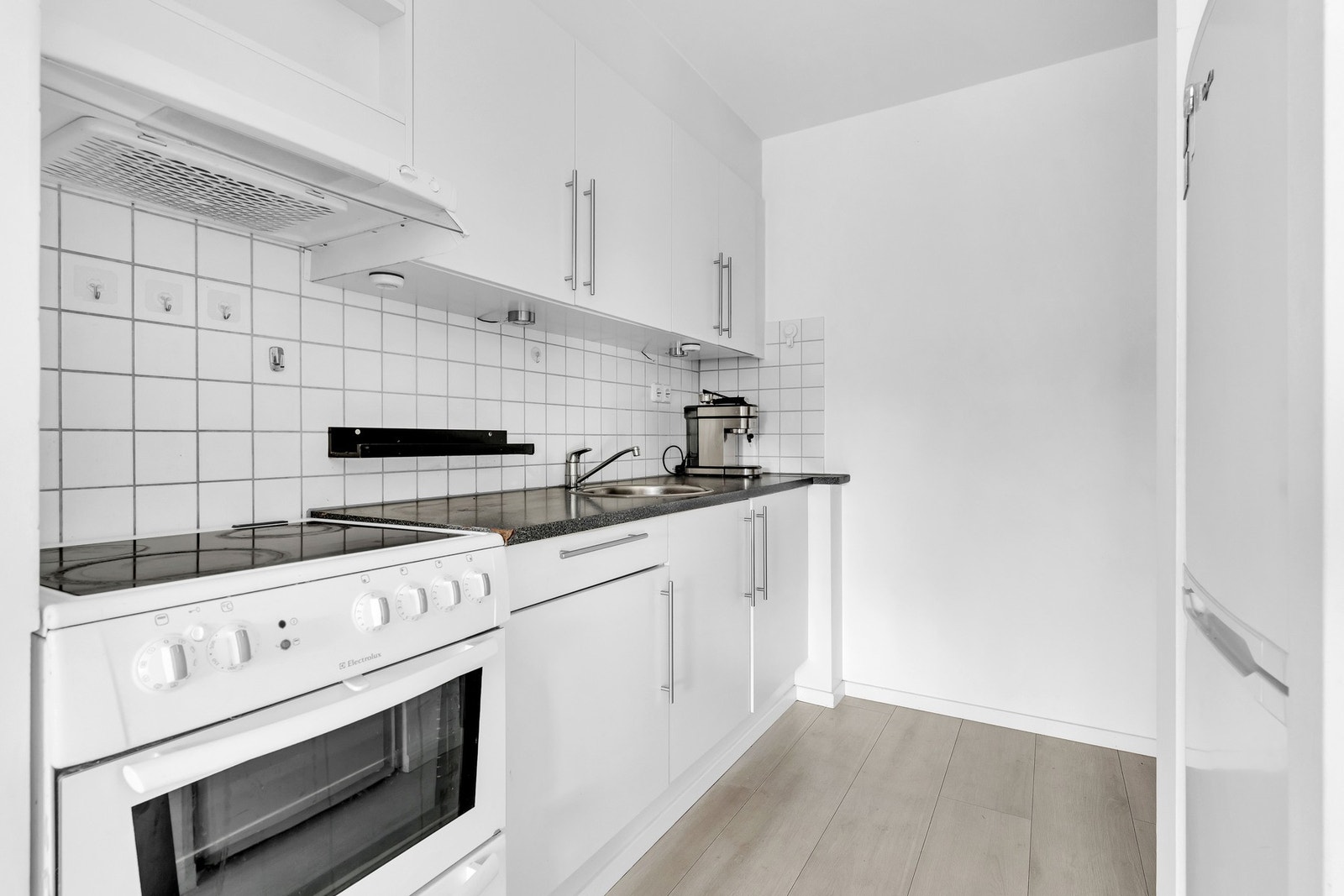 Kjøkkeninnredningen består av glatte fronter og benkeplate av laminat med oppvaskkum av rustfritt stål med ett-greps armatur Galleribilde