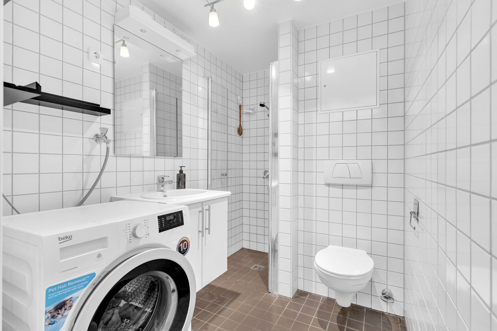 Flislagt baderom fra byggeåret 2004 med vegghengt servantskap, vegghengt toalett, dusjhjørne og opplegg for vaskemaskin Galleribilde