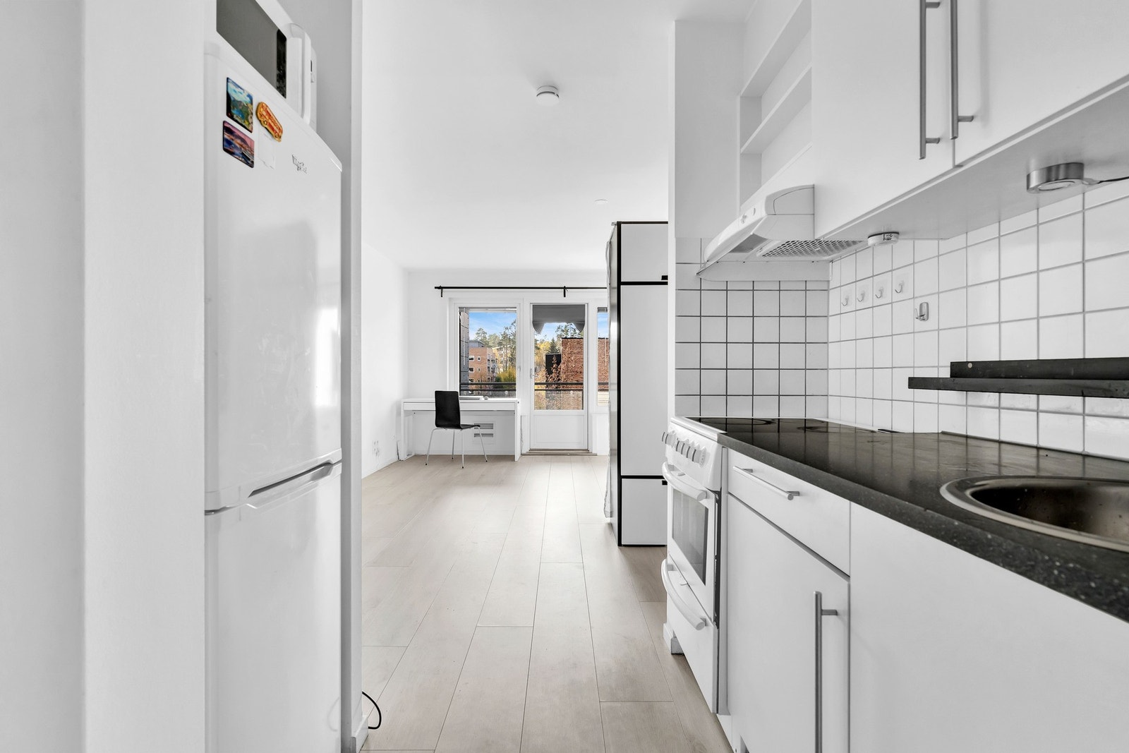 På kjøkkenet er det også komfyr med platetopp, kjøkkenventilator tilkoblet avtrekkskanal og frittstående kjøleskap med frysedel Galleribilde