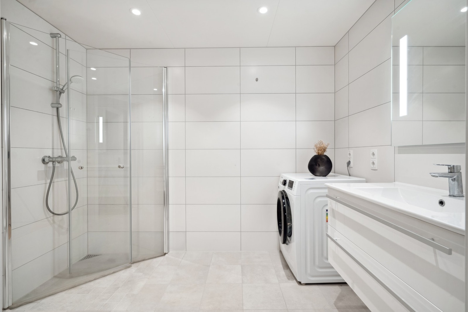 Flott flislagt bad med opplegg for vaskemaskin. Galleribilde