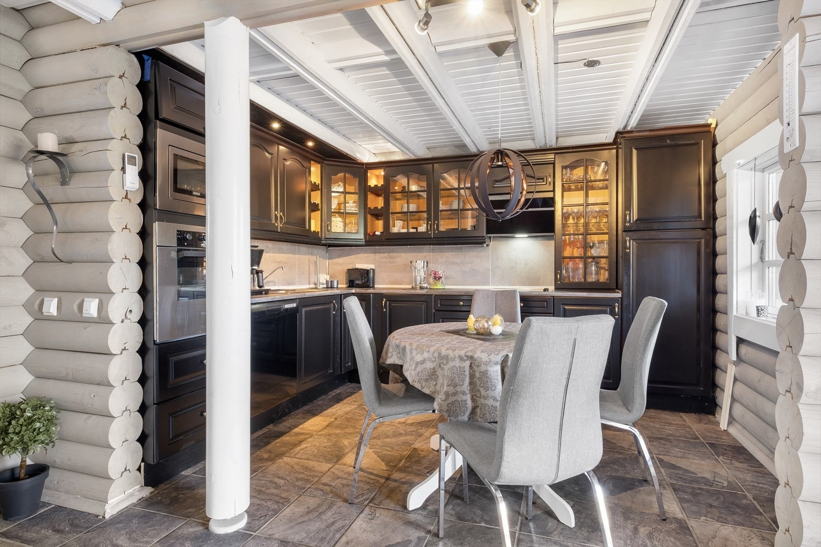 Stort kjøkken som har godt med benkeplass og skapplass og det er flislagt på gulvet. Integrerte hvitevarer og oppvaskmaskin på kjøkkenet Galleribilde