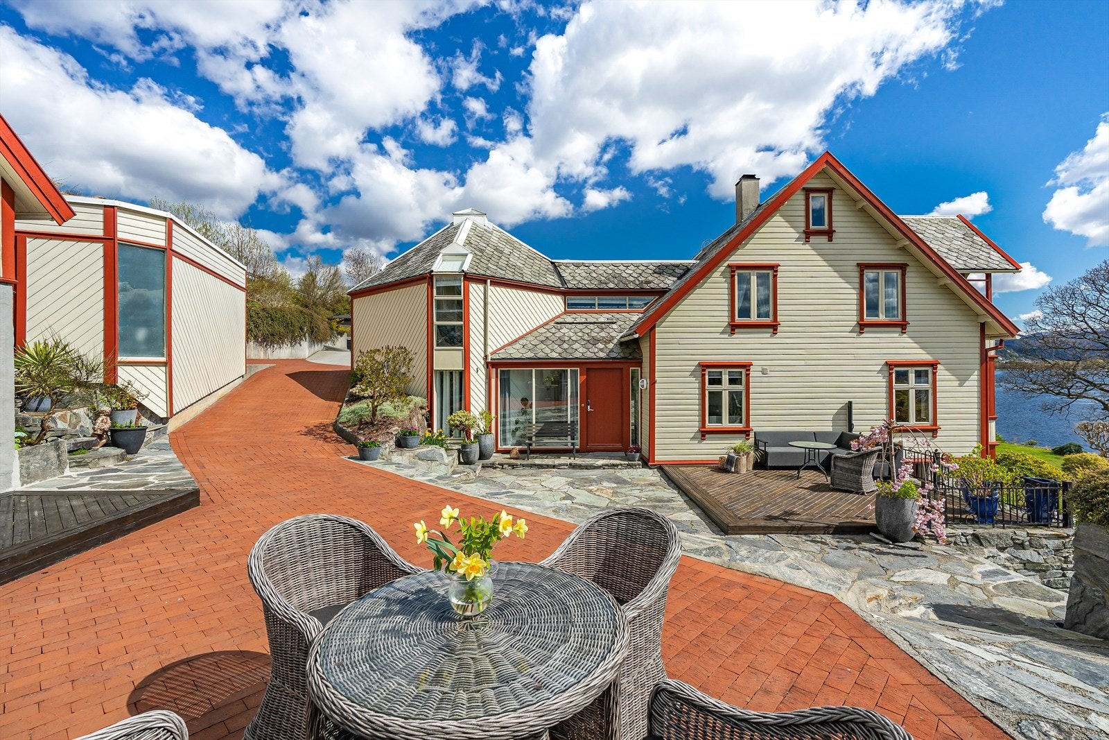 Det er mange kjekke terrasser, plattinger og oppholdssoner rundt omkring på eiendommen, så her kan man flytte seg rundt etter vær og vind Galleribilde