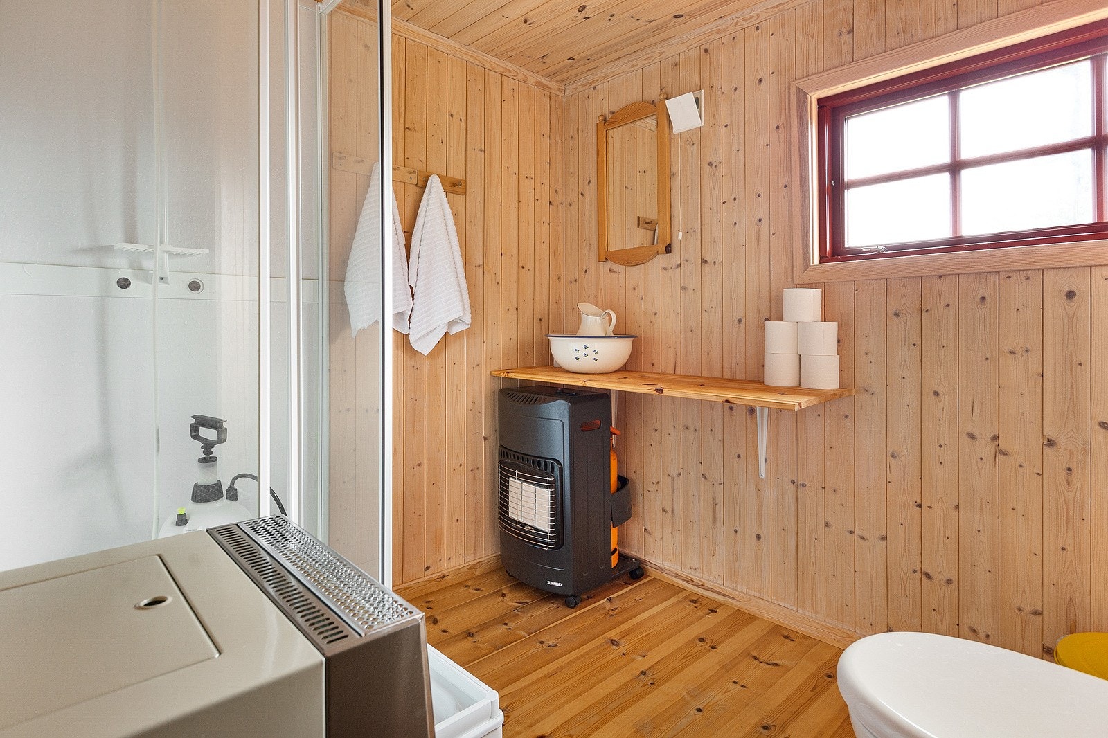 Pent baderom som er innredet med hytte-dusjkabinett, jets vakuumtoalett og benk med vaskefat. Ventil i yttervegg. Oppfyring med flyttbar gassovn. Galleribilde