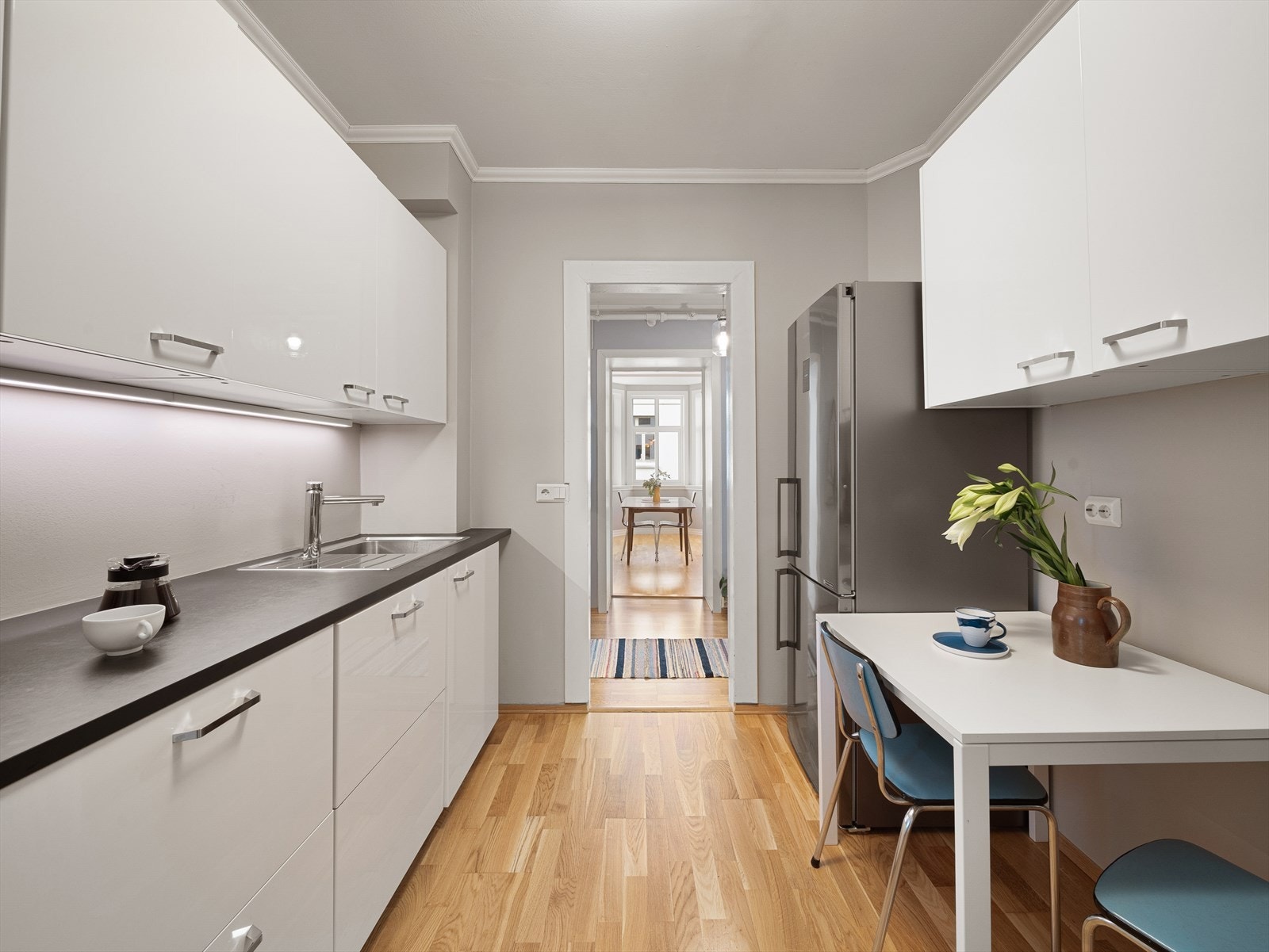 Kjøkkeninnredning fra IKEA fra ca. 2014 med hvite slette fronter og mørk laminat benkeplate. Galleribilde