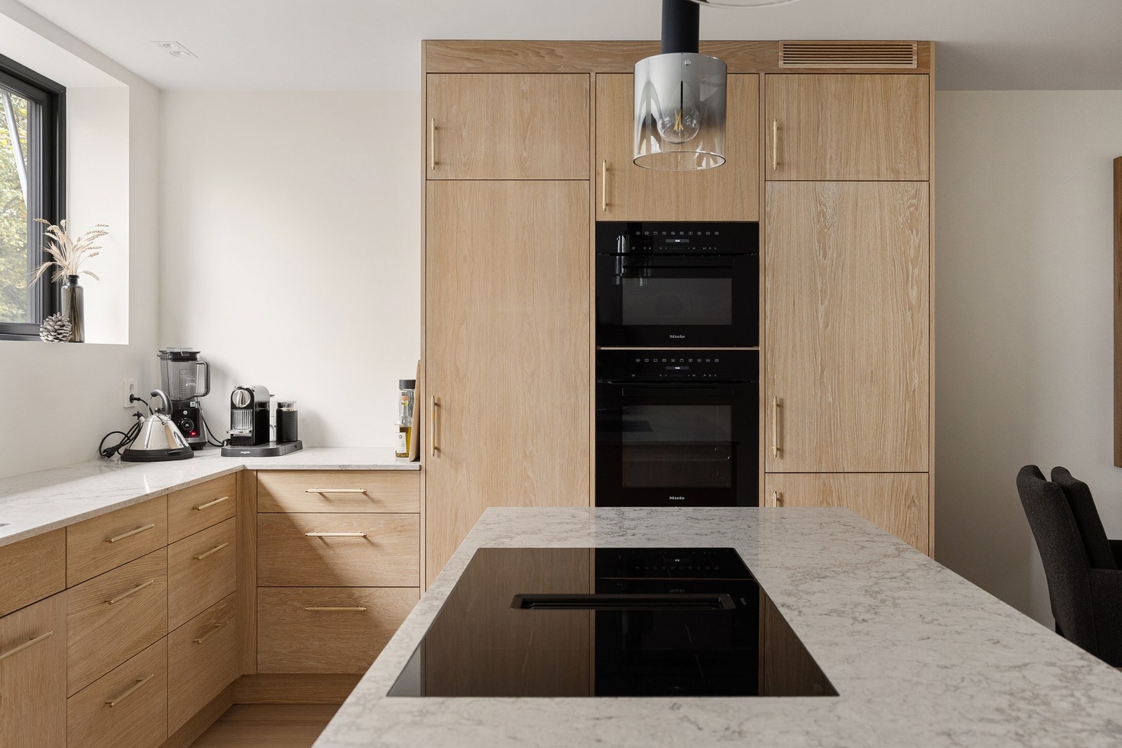 Innredningen fra 2023 er levert av Gjeving Trevarefabrikk og har glatte fronter med trestruktur og hvit benkeplate av stein med nedfelt oppvaskkum. Galleribilde