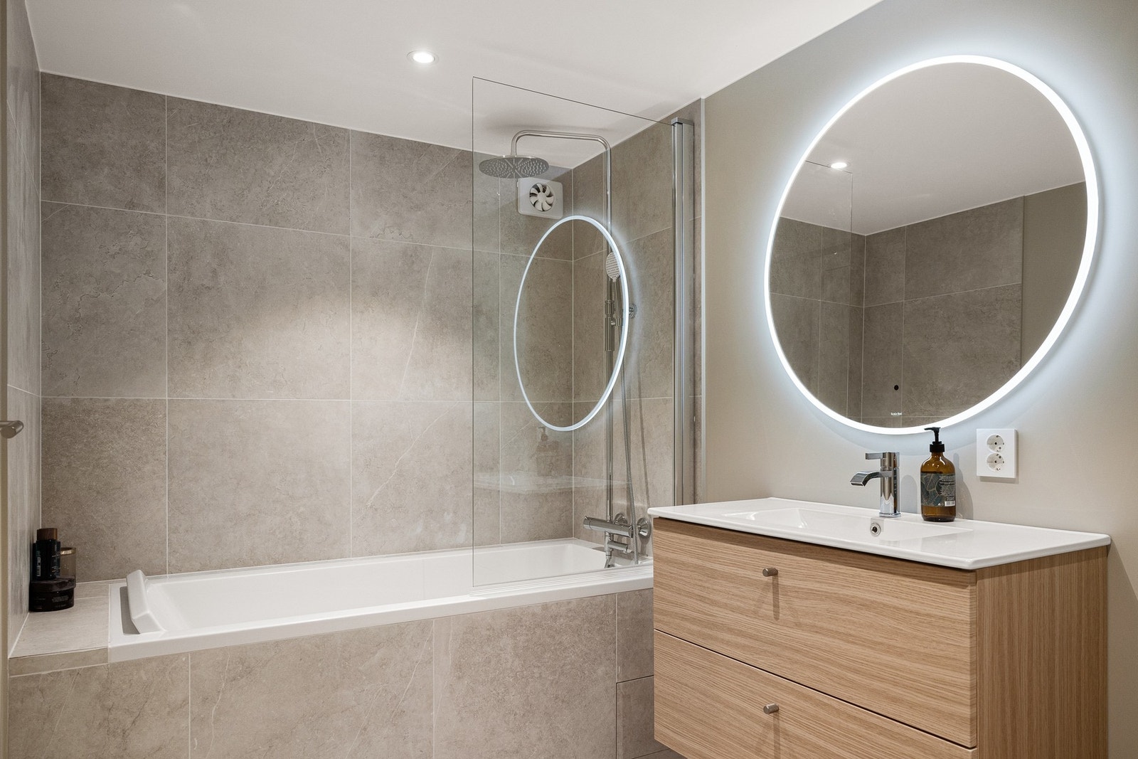 Badet i 1. underetasje har et innfliset badekar med glassvegg og regnfallsdusj. Galleribilde