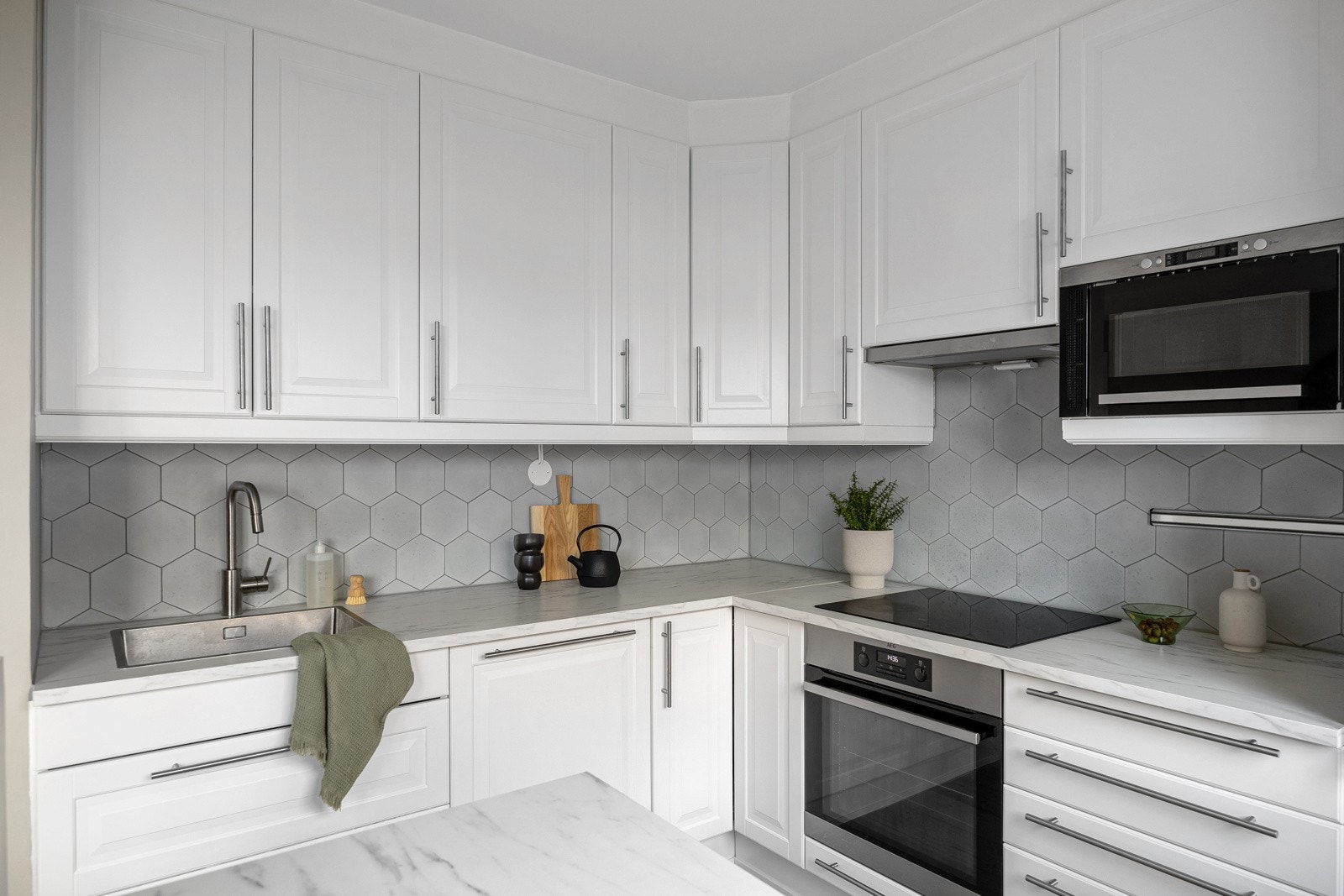 Over kjøkkenbenken finner du fliser på veggen, benkebelysning og stikkontakter som gjør kjøkkenet funksjonelt og praktisk. Galleribilde