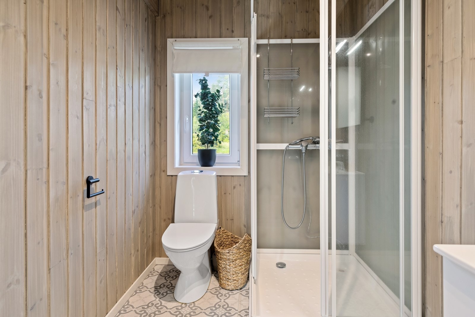 Badet har flislagt gulv med nedsenk i dusjhjørne. Galleribilde